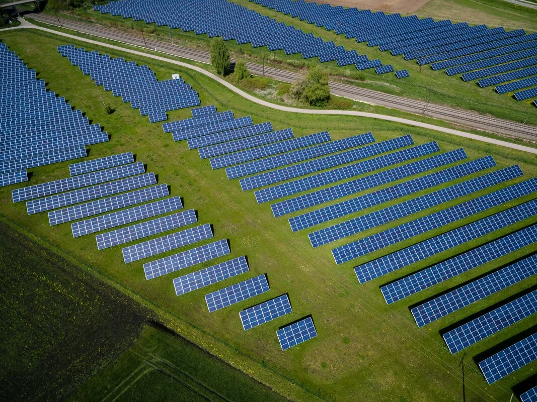 Wind turbines and solar panels in a green landscape, symbolizing sustainable energy investments and environmental responsibility